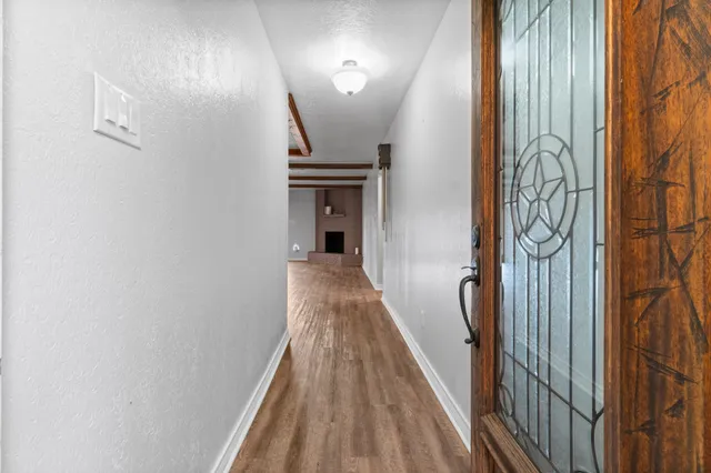 a view of a hallway with wooden floor and stairs