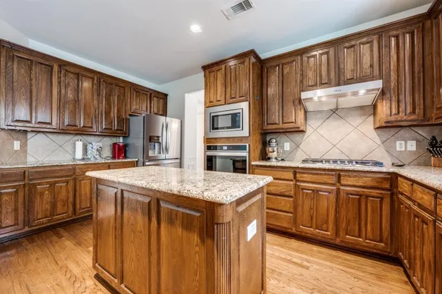 a kitchen with stainless steel appliances granite countertop a sink stove and cabinets