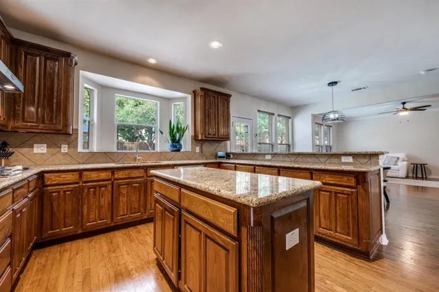 a kitchen with stainless steel appliances granite countertop wooden cabinets a sink and a stove