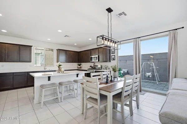 a dining hall with stainless steel appliances a table and chairs