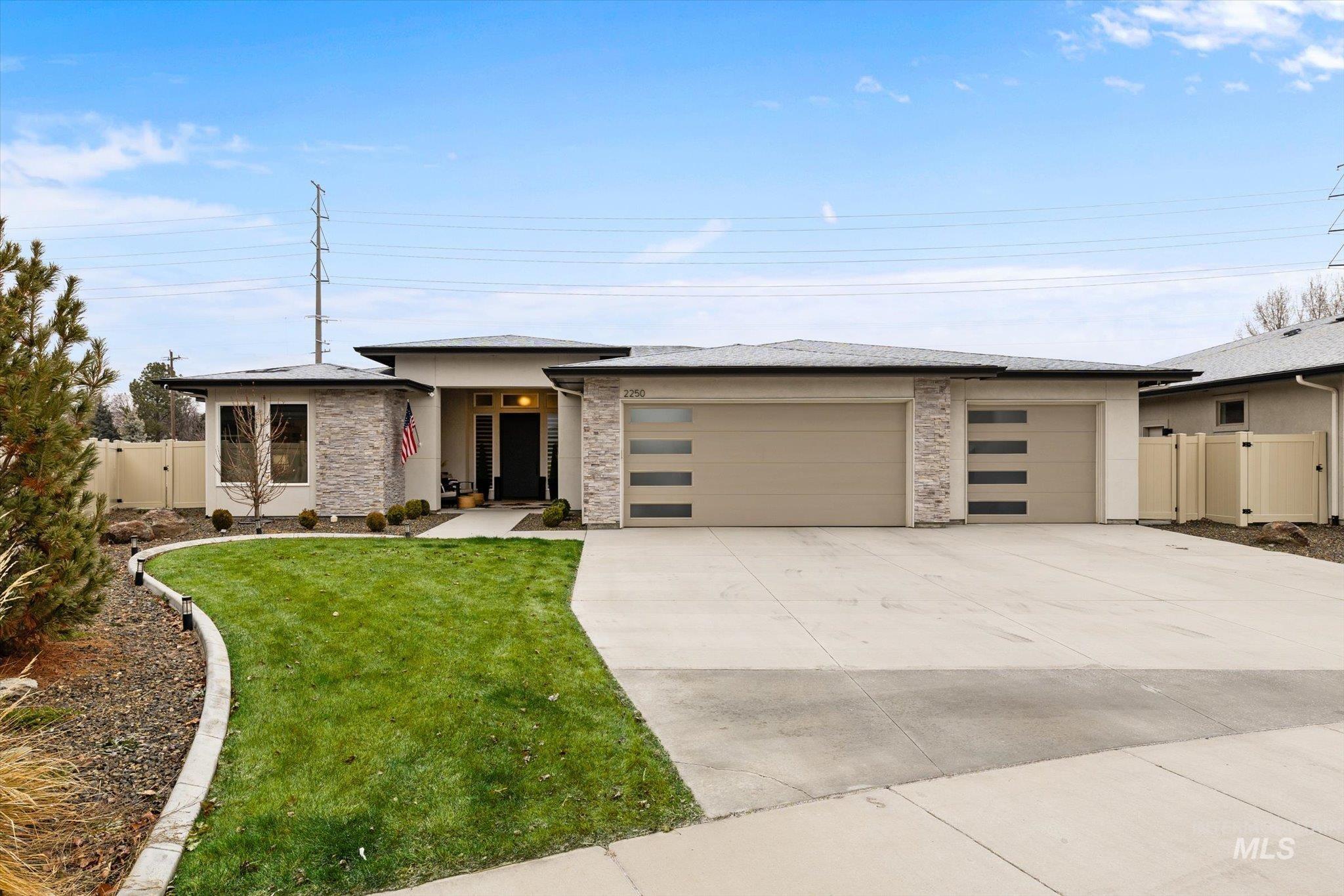 Prairie-style home with a garage, concrete driveway, a gate, and stucco siding