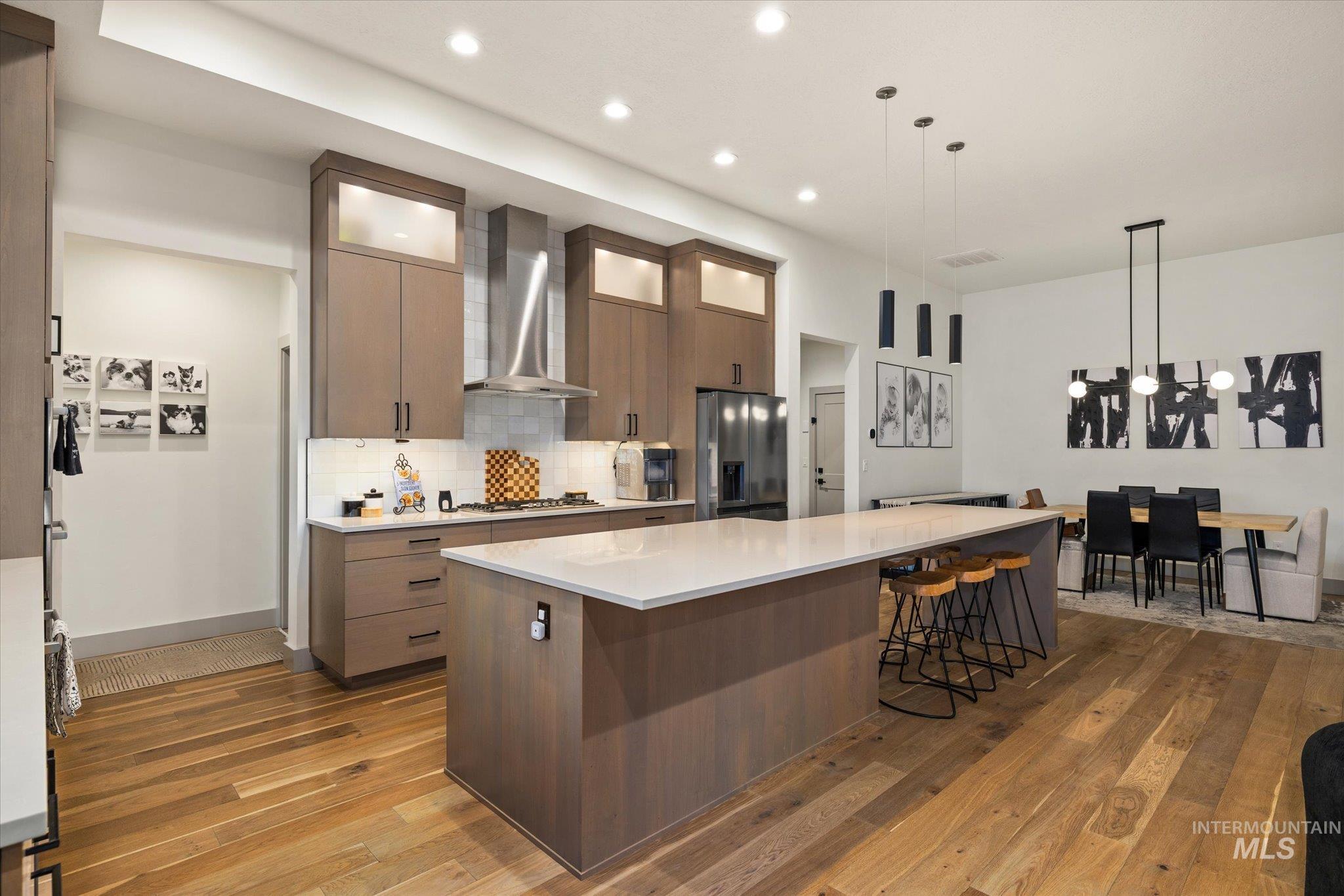 2250 South Steichen Way Meridian, ID 83642 - Photo 14 of 40 Kitchen with decorative light fixtures, a large island, wall chimney range hood, modern cabinets, and dark wood-style flooring