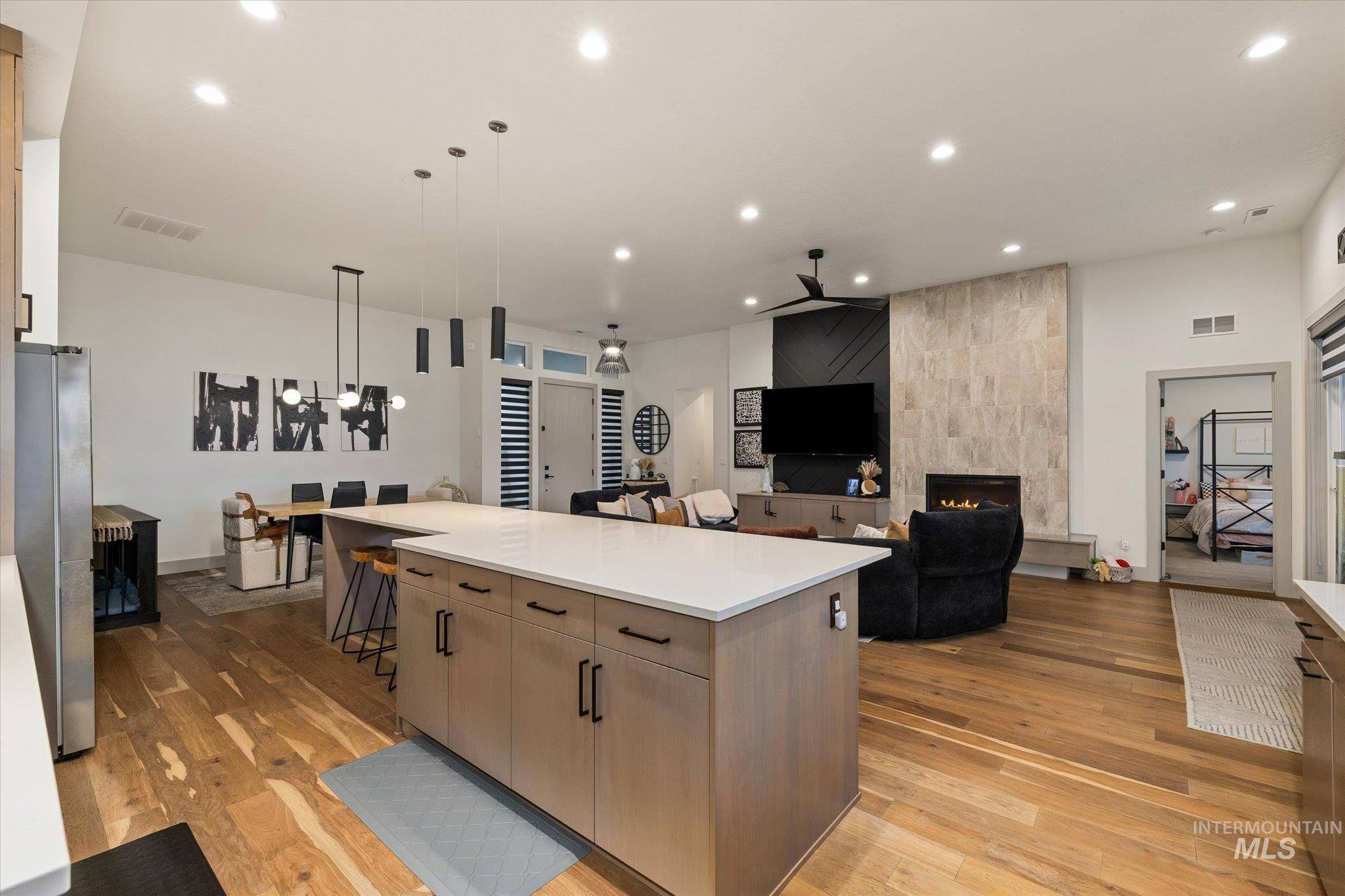 2250 South Steichen Way Meridian, ID 83642 - Photo 40 of 40 Kitchen with decorative light fixtures, light wood finished floors, a fireplace, recessed lighting, and open floor plan