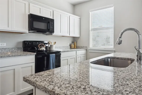 a kitchen with granite countertop a sink and a window