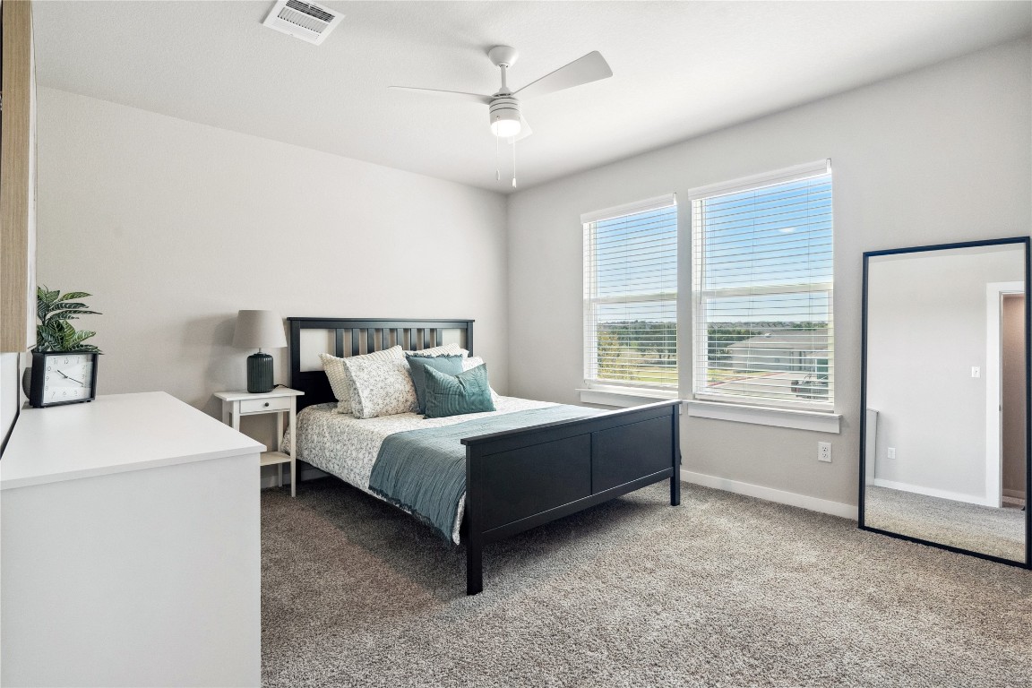 523 Powell Drive, Unit 1101 Leander, TX 78641 - Photo 17 of 24 Carpeted bedroom featuring a ceiling fan and baseboards