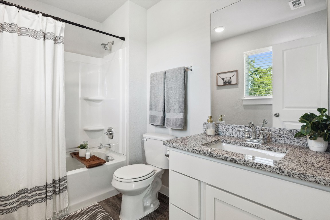 523 Powell Drive, Unit 1101 Leander, TX 78641 - Photo 19 of 24 Bathroom featuring vanity, shower / tub combo, and dark wood finished floors