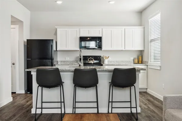 a kitchen with stainless steel appliances granite countertop a refrigerator and microwave