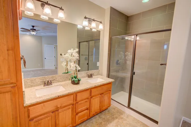 a bathroom with a double vanity sink mirror and shower