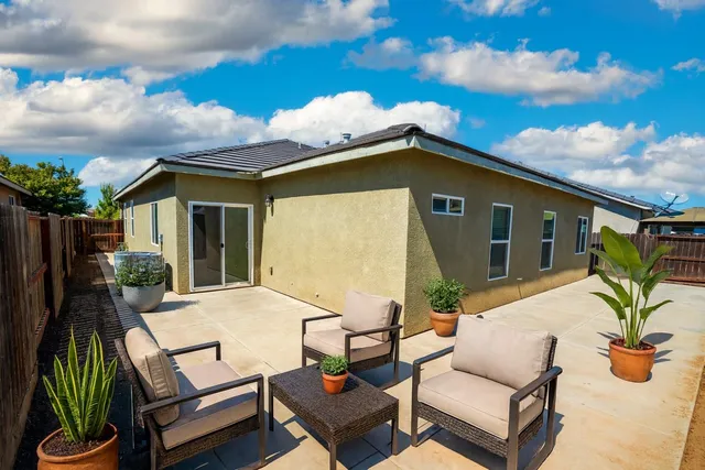 a backyard of a house with table and chairs
