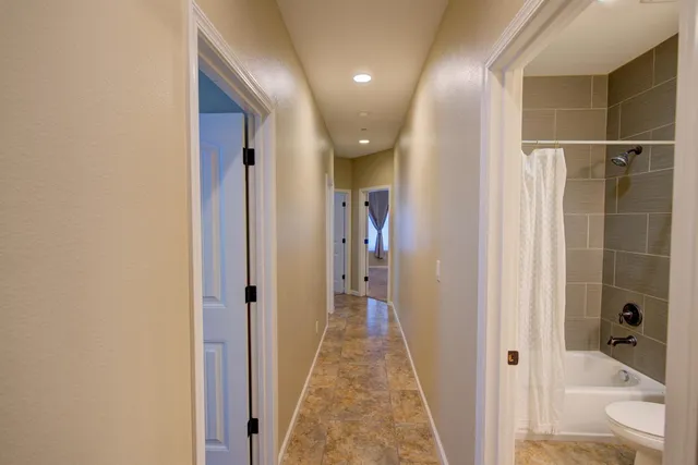 a view of a hallway with a glass door and furniture