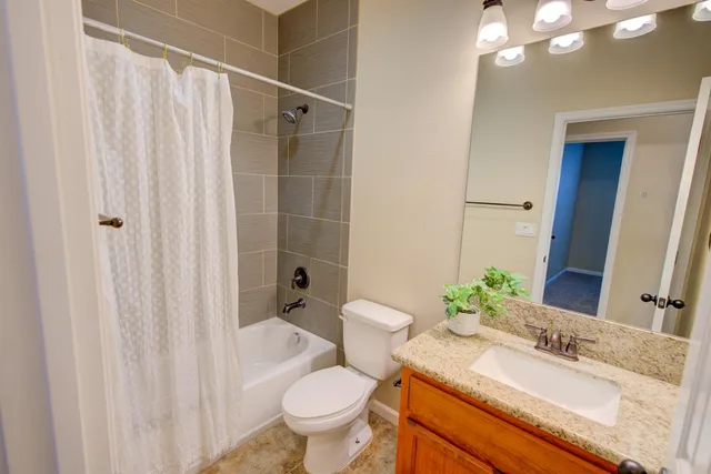 a bathroom with a granite countertop sink toilet and shower