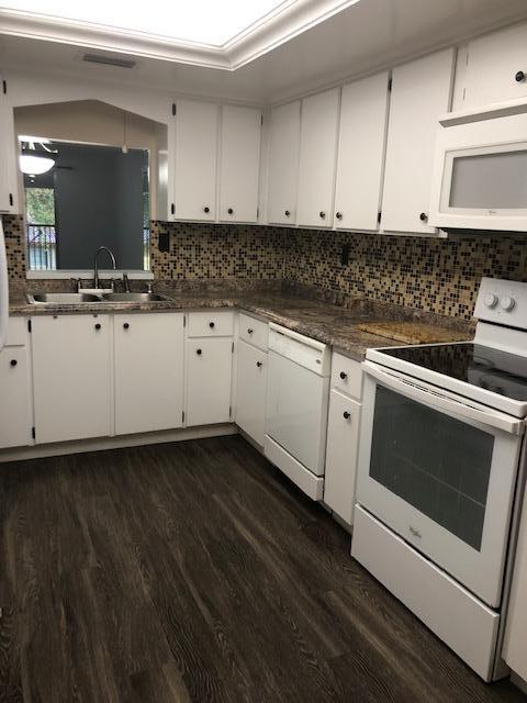 8978 West Sample Road, Unit 203 Coral Springs, FL 33065 - Photo 4 of 13 a kitchen with granite countertop white cabinets and white appliances
