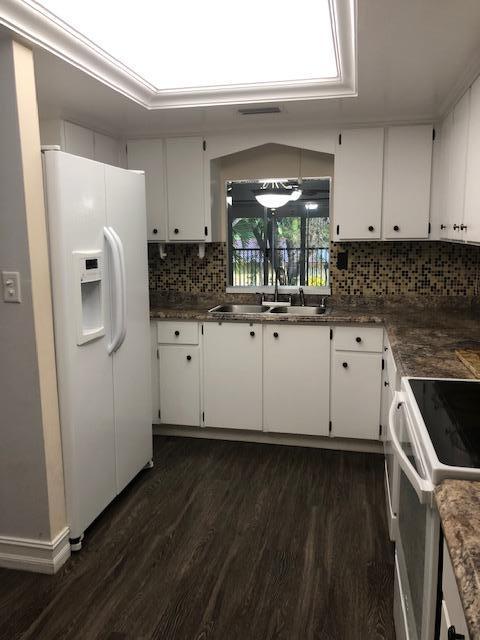 8978 West Sample Road, Unit 203 Coral Springs, FL 33065 - Photo 5 of 13 a kitchen with granite countertop a sink and a stove top oven