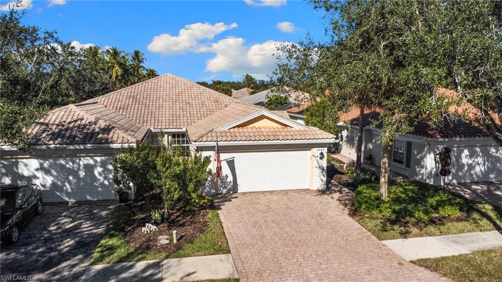 4907 Kingston Way Naples, FL 34119 - Photo 1 of 49 a front view of a house with a yard and garage