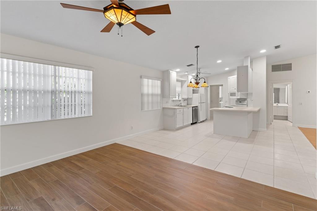 4907 Kingston Way Naples, FL 34119 - Photo 14 of 49 a living room with kitchen island furniture and a chandelier