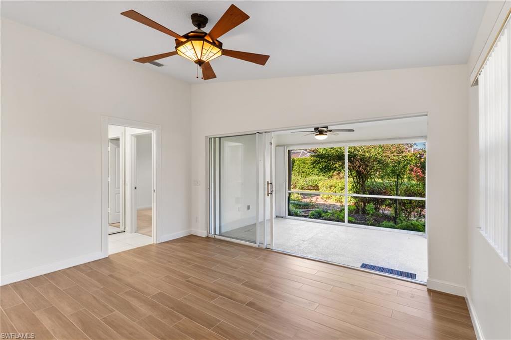 4907 Kingston Way Naples, FL 34119 - Photo 21 of 49 wooden floor in an empty room with a window