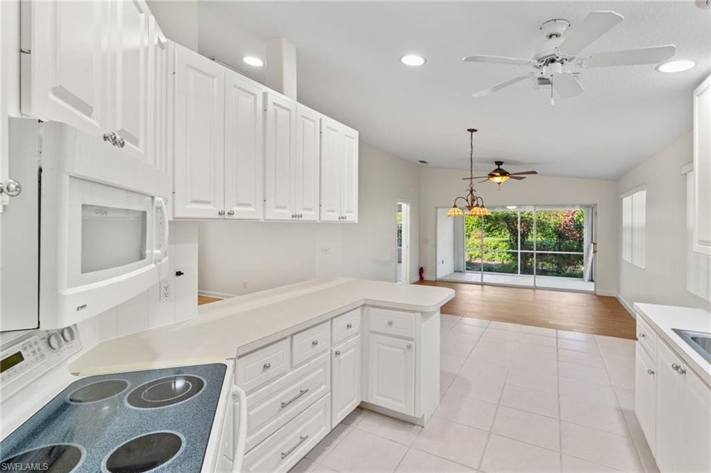 4907 Kingston Way Naples, FL 34119 - Photo 5 of 49 a kitchen with a sink window and cabinets
