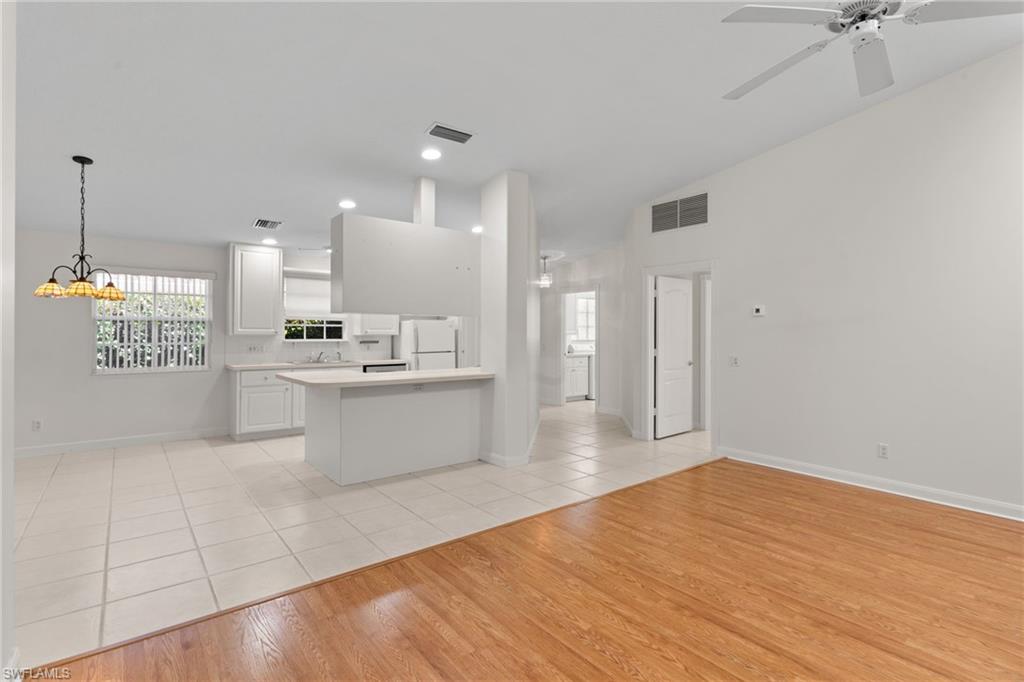 4907 Kingston Way Naples, FL 34119 - Photo 10 of 49 a large white kitchen with a large counter top and stainless steel appliances