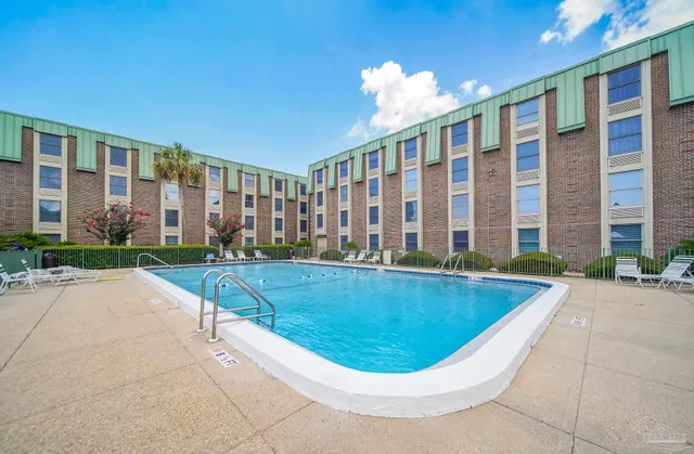 a view of a house with swimming pool and sitting area