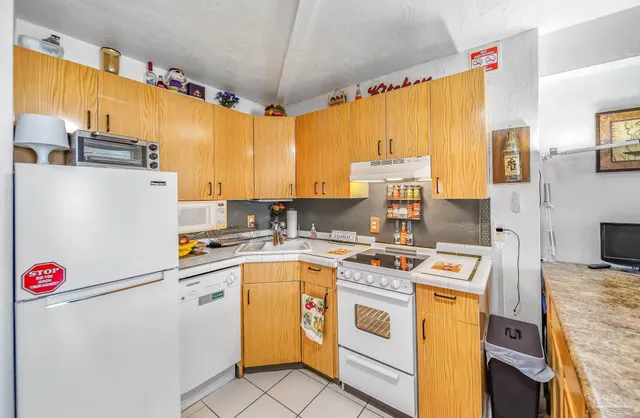 a kitchen with a sink a stove and cabinets