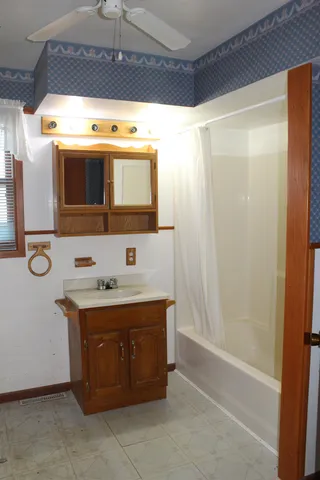 a bathroom with a granite countertop sink a mirror and a bathtub
