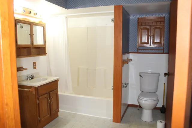 a bathroom with a granite countertop toilet a sink and a bathtub