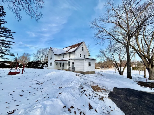 a view of a house with a yard covered in snow