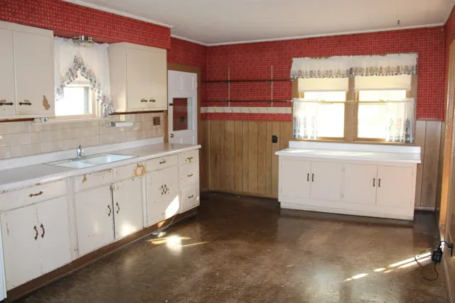 a kitchen with white cabinets and a window