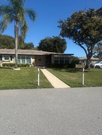 a view of a house with backyard and tree s