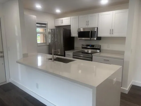 a kitchen with stainless steel appliances a refrigerator a stove a microwave and cabinets