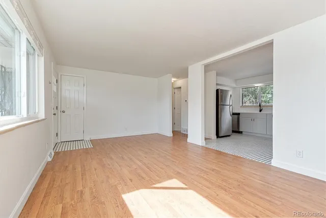 a view of empty room with wooden floor and windows