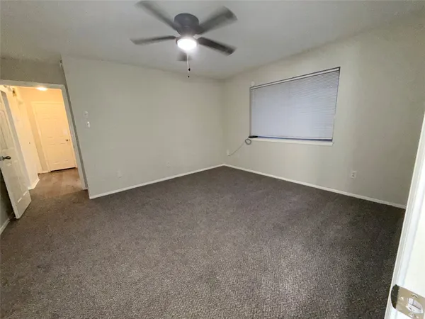 an empty room with a ceiling fan and a window