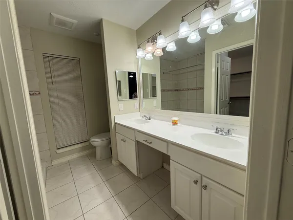 a bathroom with a double vanity sink mirror and shower