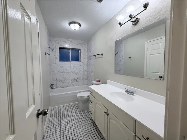 a bathroom with a sink a toilet a mirror and shower