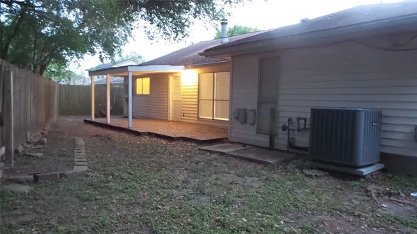 a view of a house with a yard and wooden fence
