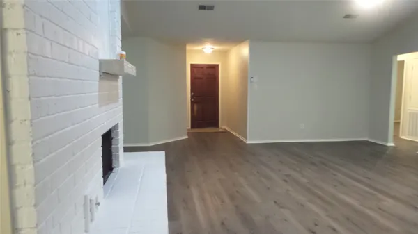 a view of a hallway with wooden floor and a fireplace
