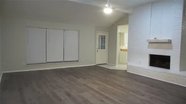 a view of a livingroom with wooden floor and a fireplace