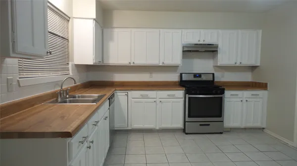a kitchen with a sink stove and cabinets