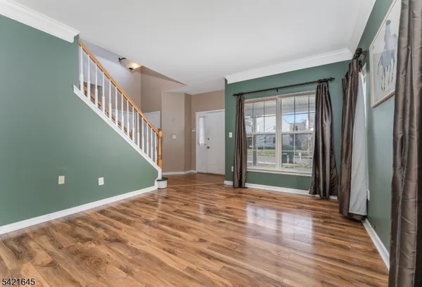 a view of a room with wooden floor and front door