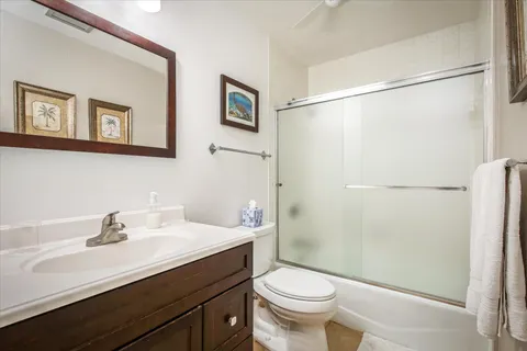 a bathroom with a sink a toilet a shower and a mirror