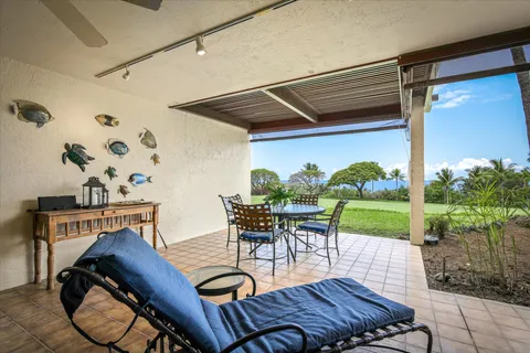 a view of a patio with lawn chairs next to a yard