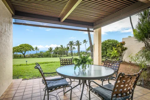 a view of a porch with furniture and a yard