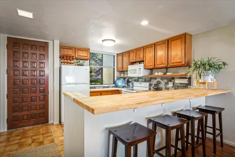 a kitchen with granite countertop a sink and a refrigerator