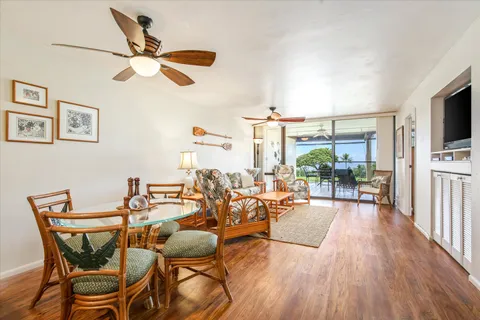 a dining room with furniture a flat screen tv and wooden floor
