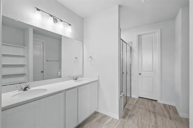 a bathroom with a double vanity sink and mirror