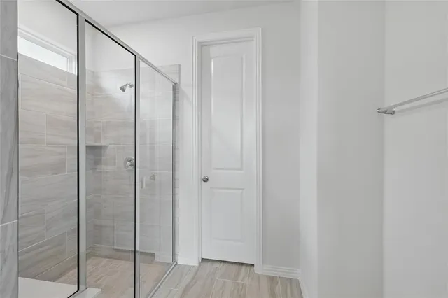 a bathroom with a glass shower door and a shower