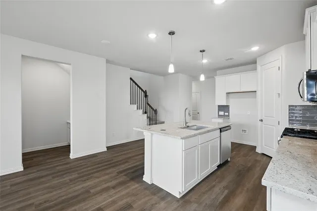 a kitchen with a sink stove and cabinets