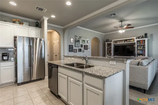 a kitchen with stainless steel appliances granite countertop a sink and a refrigerator