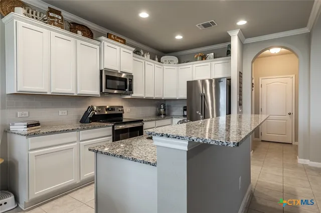 a kitchen with stainless steel appliances granite countertop a sink stove and microwave