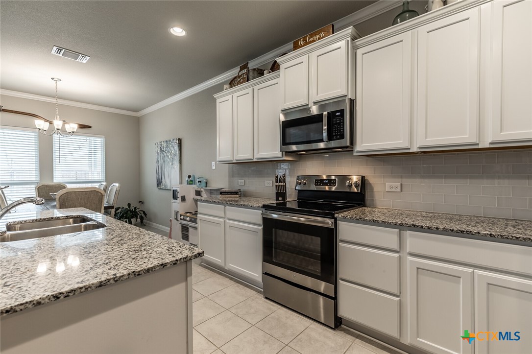 6142 Fairburn Temple, TX 76502 - Photo 16 of 38 a kitchen with stainless steel appliances granite countertop a sink stove and microwave